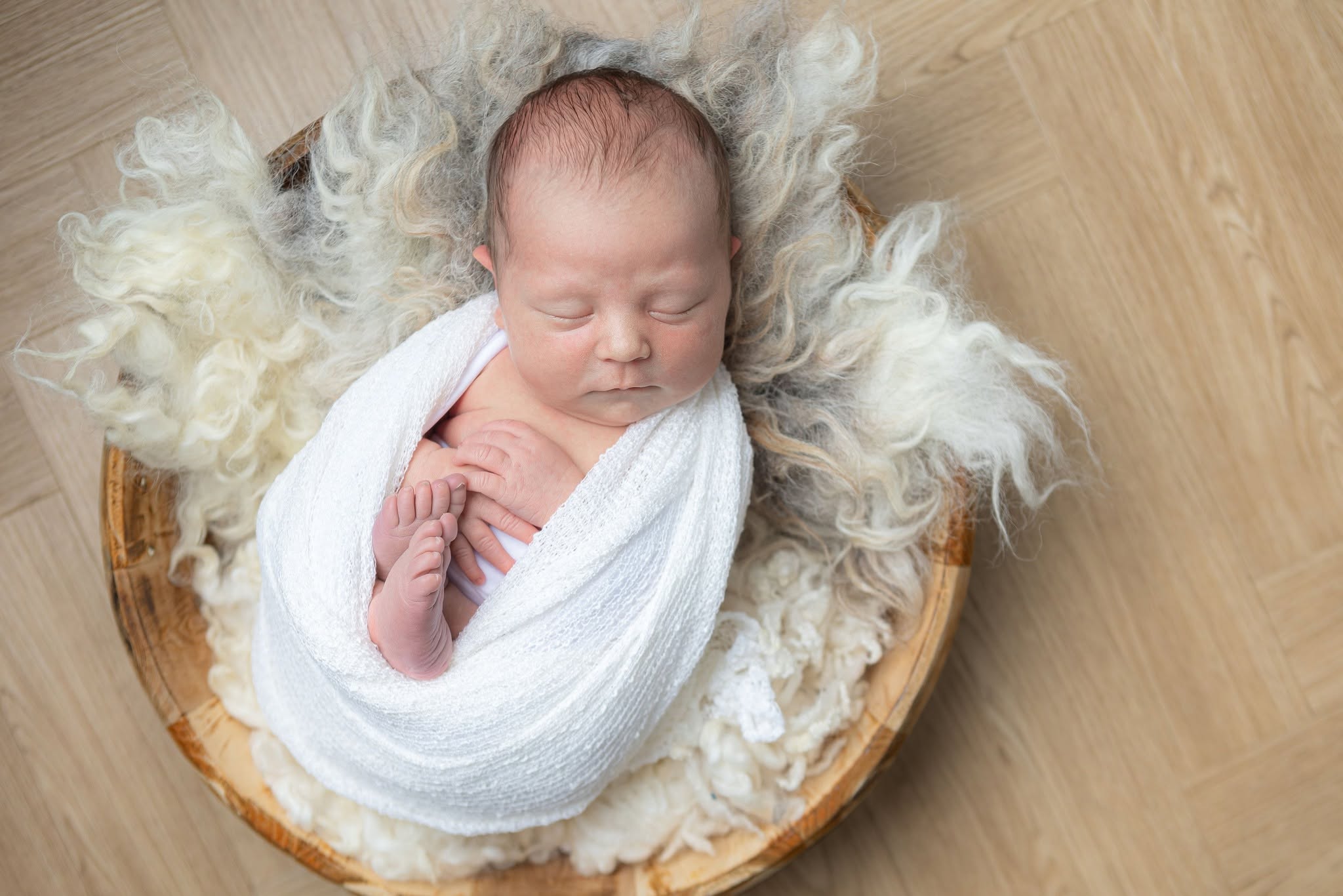 Newborn baby sleeping in a woven basket